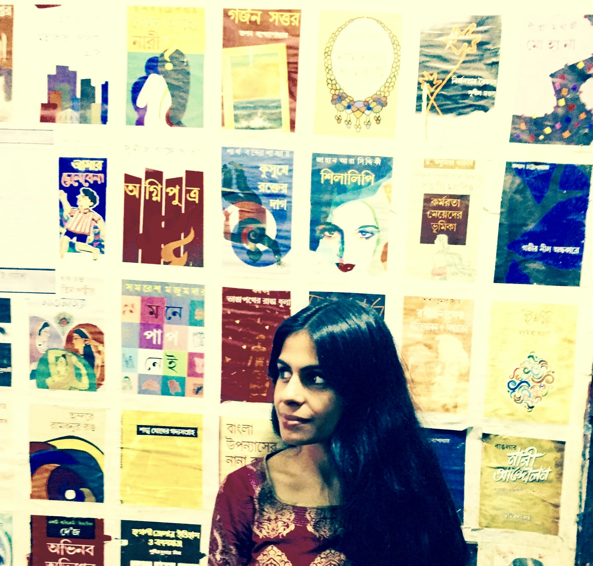 Durba Mitra in front of a wall of posters