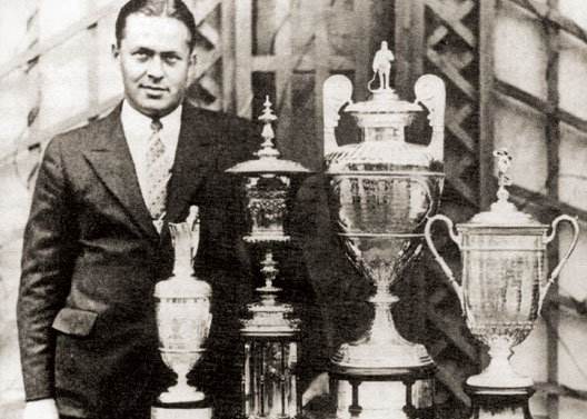 Bobby Jones standing next to a collection of trophies