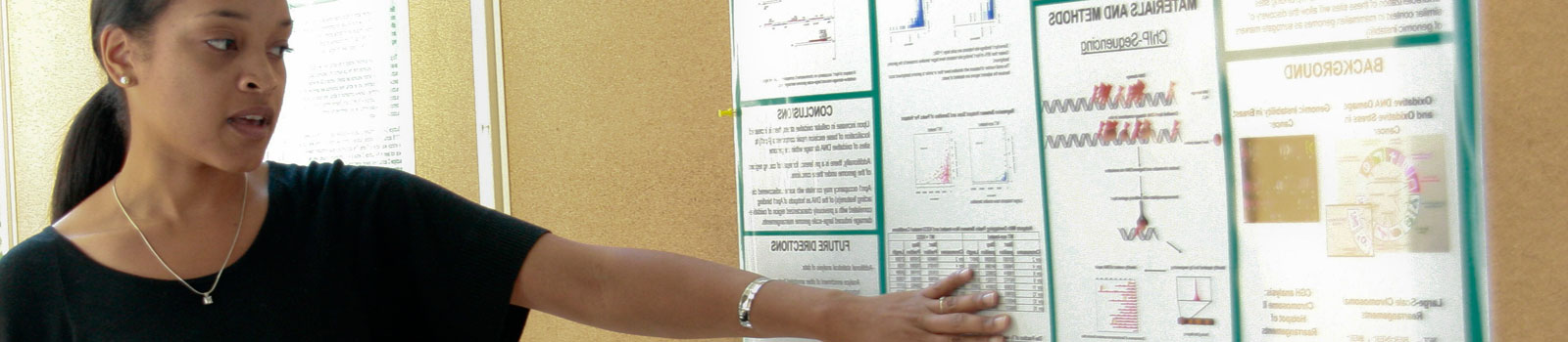 A woman speaking and pointing at a research poster