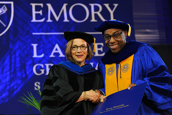 Laney Graduate School hooding ceremony photo of a male graduate posing with the Dean after being hooded. 